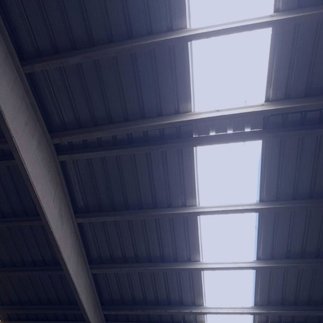 Imatge d'un sostre industrial amb bigues i xapes de ferro
